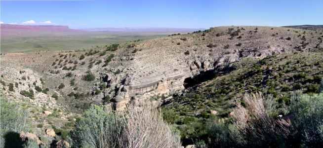 [Multiple photos stitched together to show a valley with mountains in distance.]